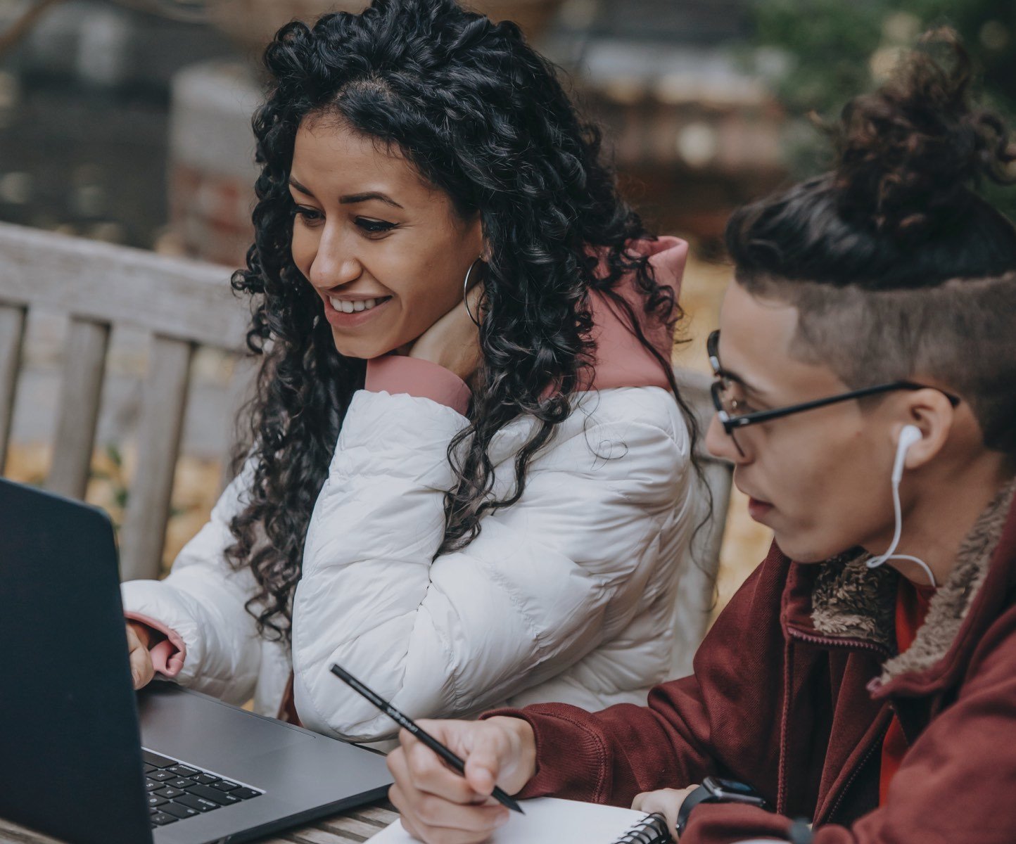 Male and female students working on laptop